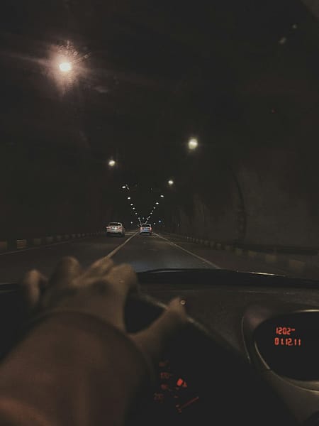 a person driving a car in a tunnel at night google maps dark mode night driving.jpg