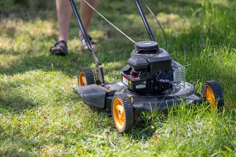 a person mowing the grass with a lawn mower robomow rs630 cutting large grass area backyard robot.jpg