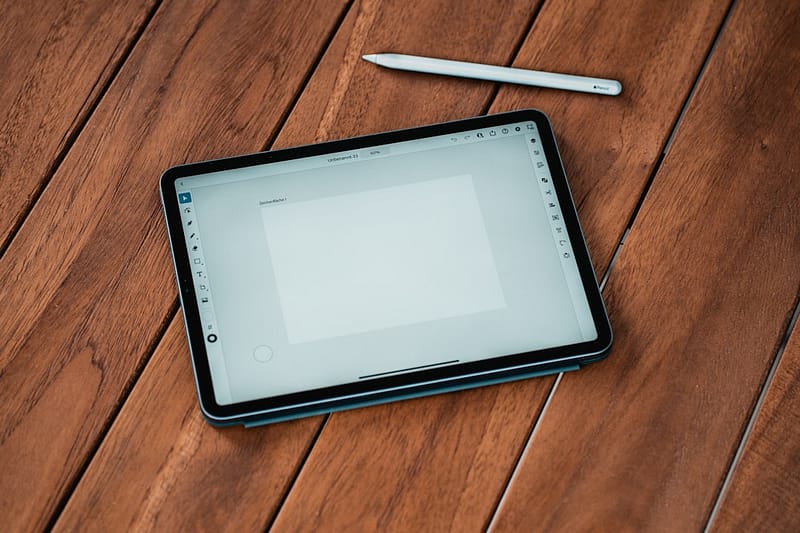 black ipad on brown wooden table surface pro 11 port layout tablet side view.jpg