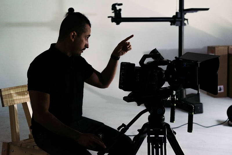 a man sitting on a chair in front of a camera corporate video film shoot storytelling.jpg