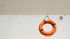 orange flotation ring hanging on wall 300x168.png