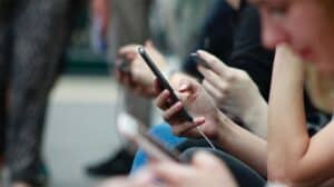 woman looking at mobile phone illustrates making easy for customers to contact business 300x168.jpg